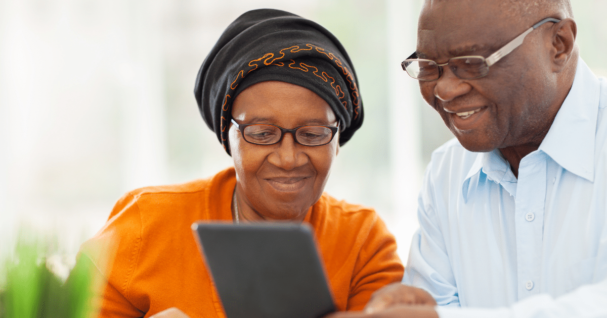 elderly couple looking at device together